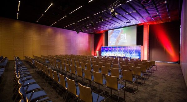 A conference hall at MCK set up with rows of chairs facing a stage